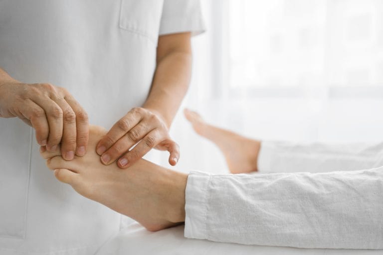 Osteopata haciendo masajes en el metatarso del pie